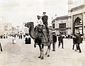 "A camel ride through the Pike." (White man riding a camel with an Egyptian driver in the Pike section of the 1904 World's Fair).jpg