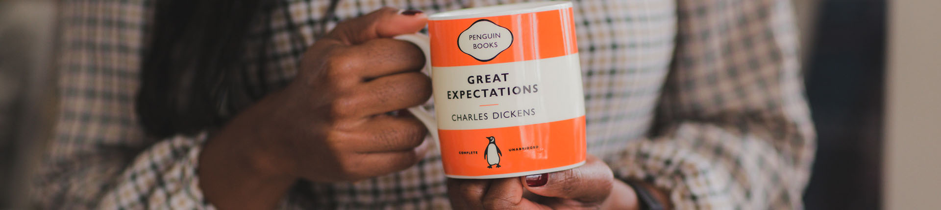 Hands holding a 'Great Expectations' Penguin Classics mug