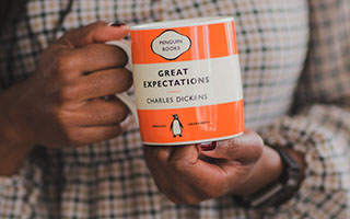 Hands holding a 'Great Expectations' Penguin Classics mug
